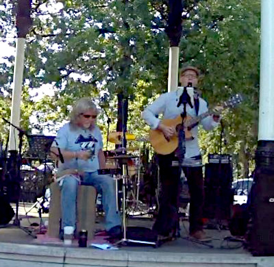 Two folk musicians playing live music outdoors